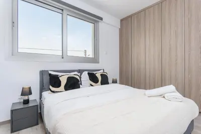 a bedroom with a large bed with black and white pillows at Mirage 2-BR Apartment in Larnaca in Larnaka