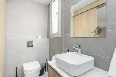 a bathroom with a white sink and a toilet at Mirage 2-BR Apartment in Larnaca in Larnaka