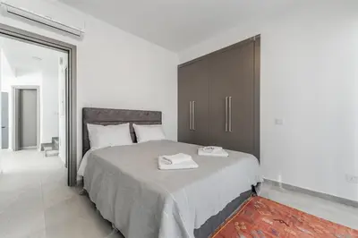 a bedroom with a large bed with a brown cabinet at Imperial Jade V2 - Villa Semeli in Protaras in Paralimni