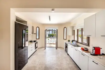 a kitchen with white cabinets and tile floors at SunnyVillas: 4BR SeaFront Villa*Private Pool*BW44 in Protaras