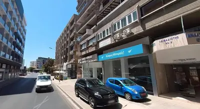 two cars parked in front of a building on a street at CityCenter Apartment in Larnaka