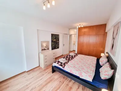 a bedroom with a bed and a dresser at CityCenter Apartment in Larnaka