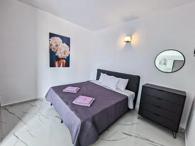 a small bedroom with a bed and a mirror at Giorgis Luxury Apartments in Ayia Napa