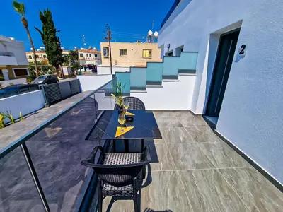 a balcony with a table and chairs and stairs at Giorgis Luxury Apartments in Ayia Napa