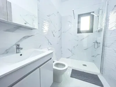 a white bathroom with a toilet and a sink at Giorgis Luxury Apartments in Ayia Napa