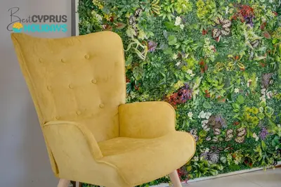 a yellow chair sitting in front of a wall at Lemon Paradise City centre 200m from beach in Larnaka