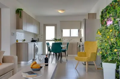 a living room and kitchen with a couch and a table at Lemon Paradise City centre 200m from beach in Larnaka