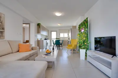 a living room with a couch and a tv at Lemon Paradise City centre 200m from beach in Larnaka
