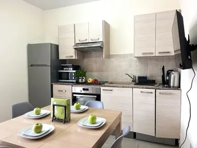 a kitchen with a wooden table and a kitchen with white cabinets at Antiparos 1 bedroom APT Kyklades in Paralimni
