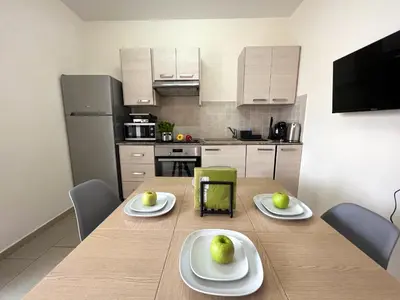 a kitchen with a wooden table with plates of fruit on it at Antiparos 1 bedroom APT Kyklades in Paralimni