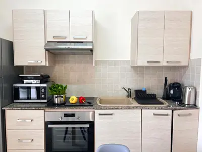 a kitchen with white cabinets and a sink and a microwave at Antiparos 1 bedroom APT Kyklades in Paralimni