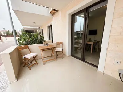 a balcony with a table and chairs on a building at Antiparos 1 bedroom APT Kyklades in Paralimni