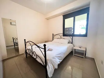 a small bedroom with a bed and a window at Antiparos 1 bedroom APT Kyklades in Paralimni