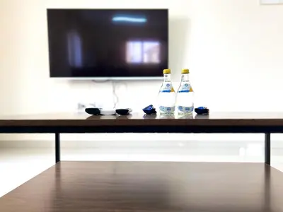 two bottles of alcohol sitting on a table in front of a tv at Paros 1 bedroom APT Kyklades in Paralimni