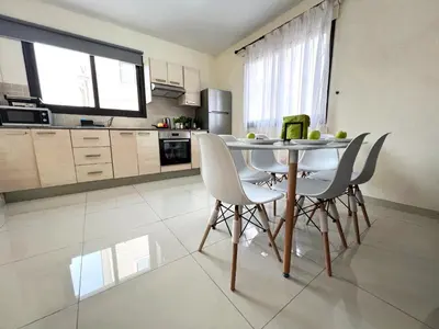 a kitchen with a table and chairs in a room at Paros 1 bedroom APT Kyklades in Paralimni