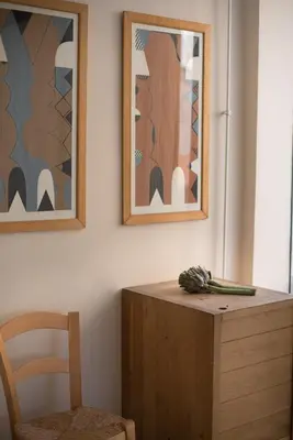 a table with a chair and two pictures on the wall at City Centre Studios in Limassol