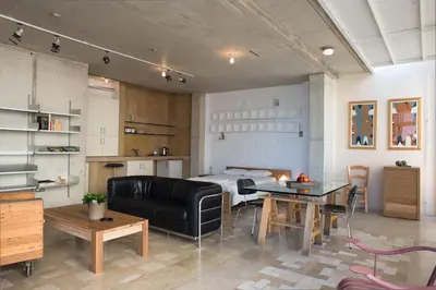 a living room with a black leather couch and a table at City Centre Studios in Limassol