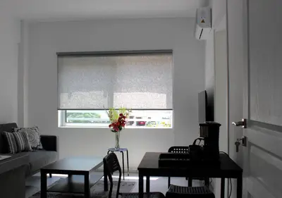 a living room with a table and a window with a blind at Amalia Residences in Nicosia