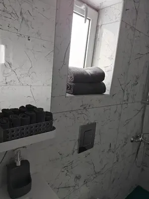 a bathroom with a mirror and a sink and towels at Amalia Residences in Nicosia