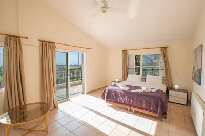 a bedroom with a bed and a large window at Papaya Royal Villa in Ayia Napa