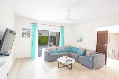 a living room with a couch and a tv at Papaya Royal Villa in Ayia Napa