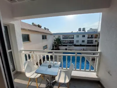 a balcony with a table and chairs and a view of the ocean at Sunny Breeze in Ayia Napa