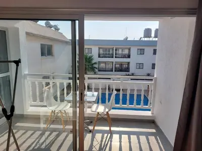 a balcony with two chairs and a view of a building at Sunny Breeze in Ayia Napa