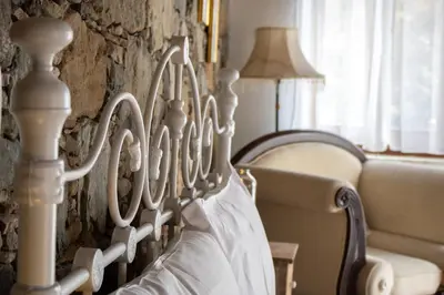 a bed frame in a room with a couch and a lamp at Morfeas Kakopetria in Kakopetria