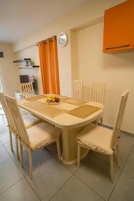 a dining room table and chairs with a bowl of fruit on it at Mezzarina apartment ayia napa in Ayia Napa