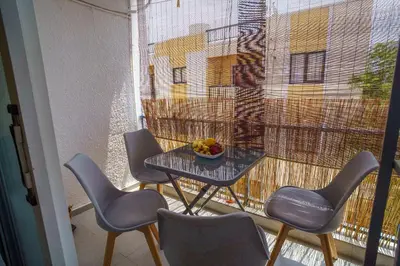 a balcony with a table with chairs and a bowl of fruit at Mezzarina apartment ayia napa in Ayia Napa