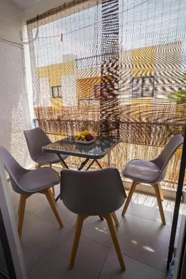 a table and chairs in a room with a window at Mezzarina apartment ayia napa in Ayia Napa