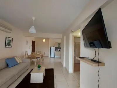 a living room with a couch and a flat screen tv at Pyla Palms Resorts A2 102 in Pyla