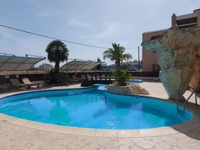 a large swimming pool in a resort with a rock at Pyla Palms Resorts A2 102 in Pyla