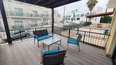 a balcony with chairs and tables and a view of a street at Cozy studio with terrace, sea views, near beaches and amenities in Ayia Napa
