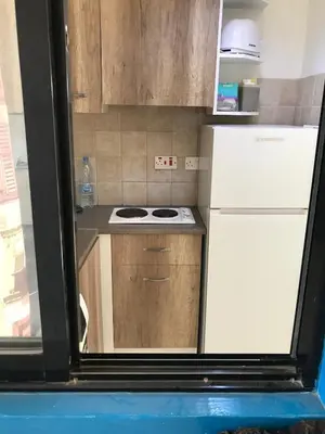 a small kitchen with a stove and a refrigerator at Cozy studio with terrace, sea views, near beaches and amenities in Ayia Napa
