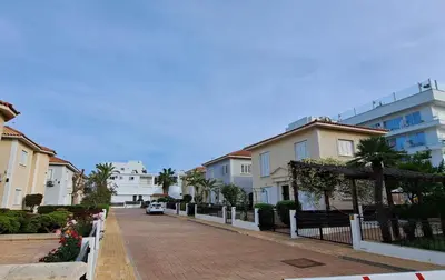 a city street with houses and a fence at VILLA MARINA BY FIG TREE BAY in Protaras