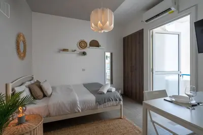 a bedroom with a bed and a table and a window at Orchid's Cozy Studio & Balcony in Larnaca in Larnaka