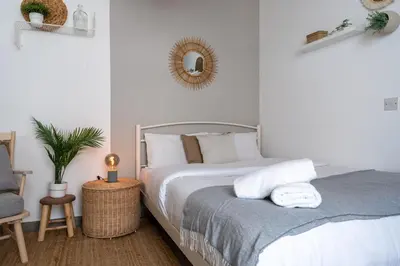 a bedroom with a bed and a chair and a mirror at Orchid's Cozy Studio & Balcony in Larnaca in Larnaka