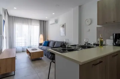 a kitchen and a living room with a couch at A Blissful 1-Bedroom Voyage in Larnaca in Larnaka