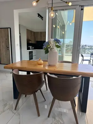 a wooden table with chairs and a vase with flowers at City Lights - Luxury Penthouse - Panoramic view - Near Unic in Nicosia