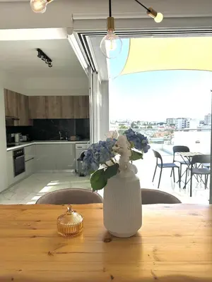 a vase of flowers sitting on a wooden table at City Lights - Luxury Penthouse - Panoramic view - Near Unic in Nicosia