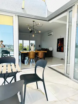 a dining room and living room with a table and chairs at City Lights - Luxury Penthouse - Panoramic view - Near Unic in Nicosia