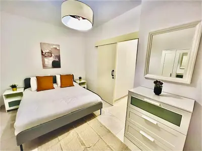 a small bedroom with a bed and a mirror at LINA 25 in Larnaka