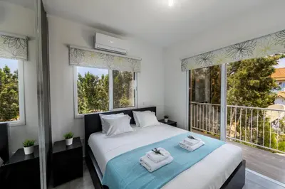 a bedroom with two towels on a bed with windows at Napa Bay View Villa 8 in Ayia Napa