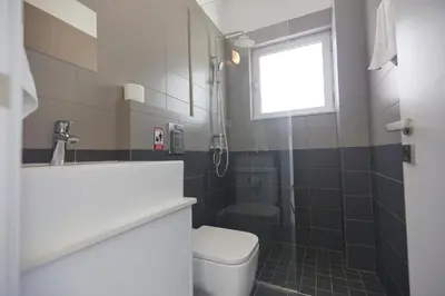a small bathroom with a toilet and a window at Protaras Olivine Villa Ol01 in Paralimni