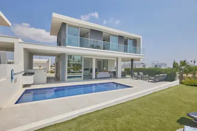 a villa with a swimming pool in front of a house at Protaras Olivine Villa Ol01 in Paralimni