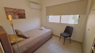 a small bedroom with a bed and a chair at STAY Mermaid's Cove in Limassol