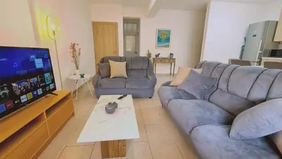 a living room with two couches and a flat screen tv at STAY Mermaid's Cove in Limassol