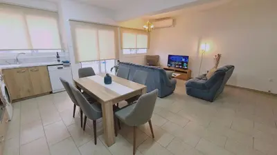 a kitchen and a living room with a table and chairs at STAY Mermaid's Cove in Limassol
