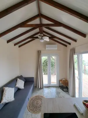 a living room with a ceiling fan and a couch at Sunset Retreat Cyprus in Pendakomo
